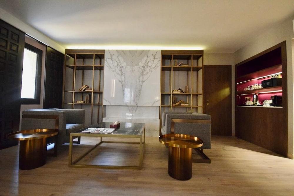 Makarem Ajyad Makkah Hotel Мекка Экстерьер фото The photo shows a modern and stylish interior space, likely a living room or lounge area. On the left side, there are two comfortable gray armchairs positioned toward the center. A glass coffee table sits between them, featuring a few magazines or bo