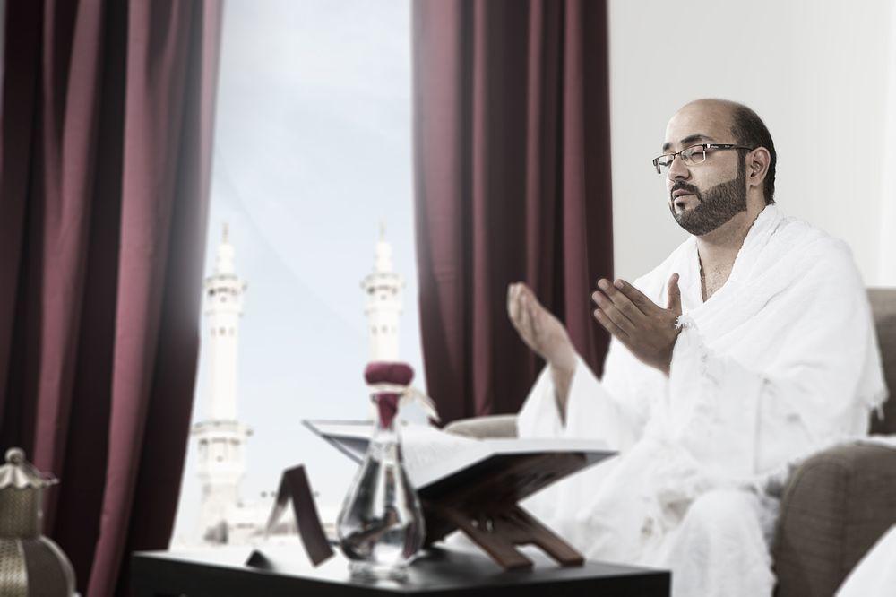 Makarem Ajyad Makkah Hotel Мекка Экстерьер фото The photo depicts a man sitting in a room, wearing traditional white garments typically associated with the Hajj pilgrimage. He appears to be engaged in a prayer or spiritual practice, with his hands raised in a gesture of supplication. In the backgr