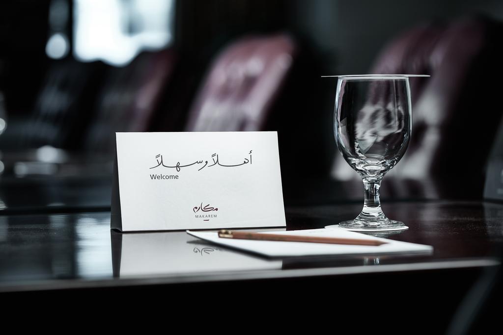 Makarem Ajyad Makkah Hotel Мекка Экстерьер фото The photo depicts a well-arranged table setting. There is a card in both Arabic and English that says "Welcome," placed on the table. Next to the card, there is a clear glass and a pen resting on a piece of paper. The background features leather seat